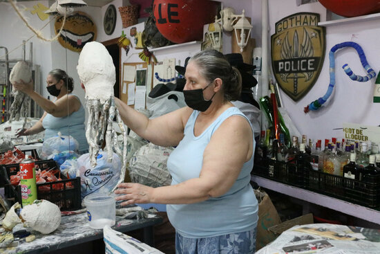 A Sants resident holds up one of the papier-mâché jelly fish that will soon decorate her street (by Carola López)